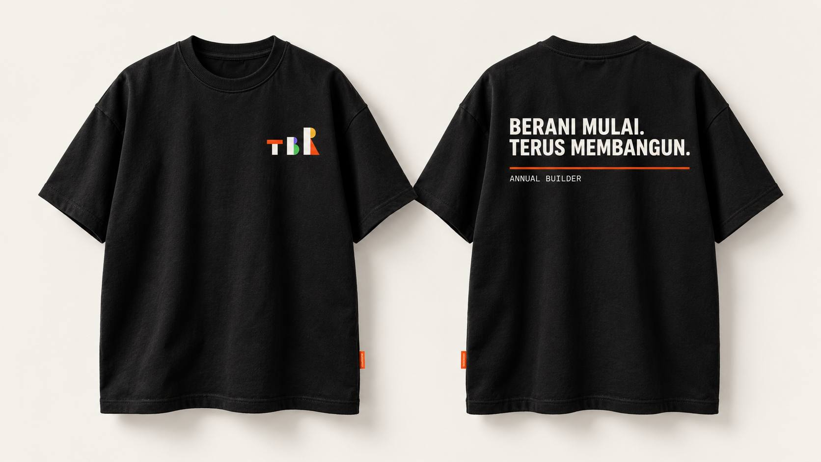 Kaos hitam tampak depan dengan logo TBR kecil di dada, dan tampak belakang bertuliskan BERANI MULAI. TERUS MEMBANGUN.